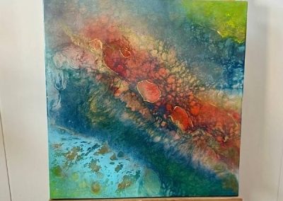 Abstract resin artwork featuring a dynamic blend of deep ocean blues, vibrant reds, and earthy textures. Inspired by natural elements and flowing movement, this unique piece adds depth, energy, and a modern artistic touch to any interior.